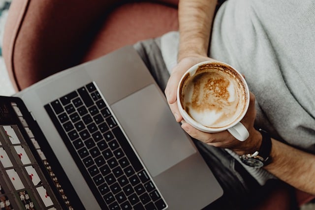 man behind laptop with coffee